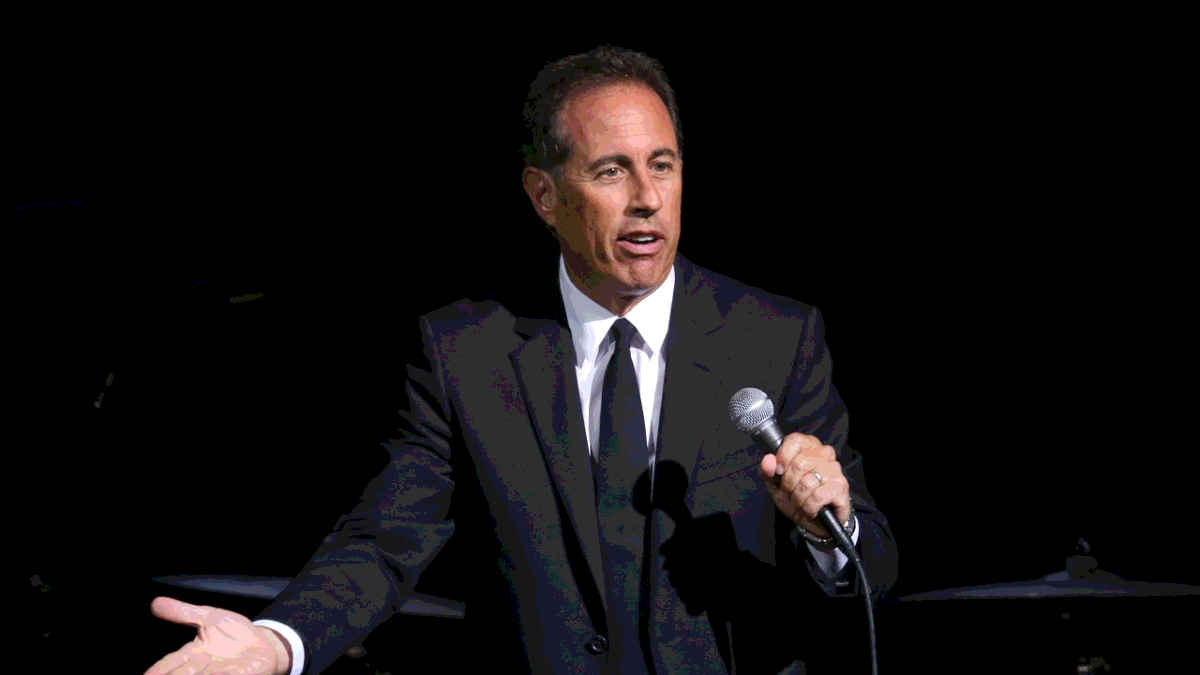 Comedian Jerry Seinfeld doing stand up comedy on stage
