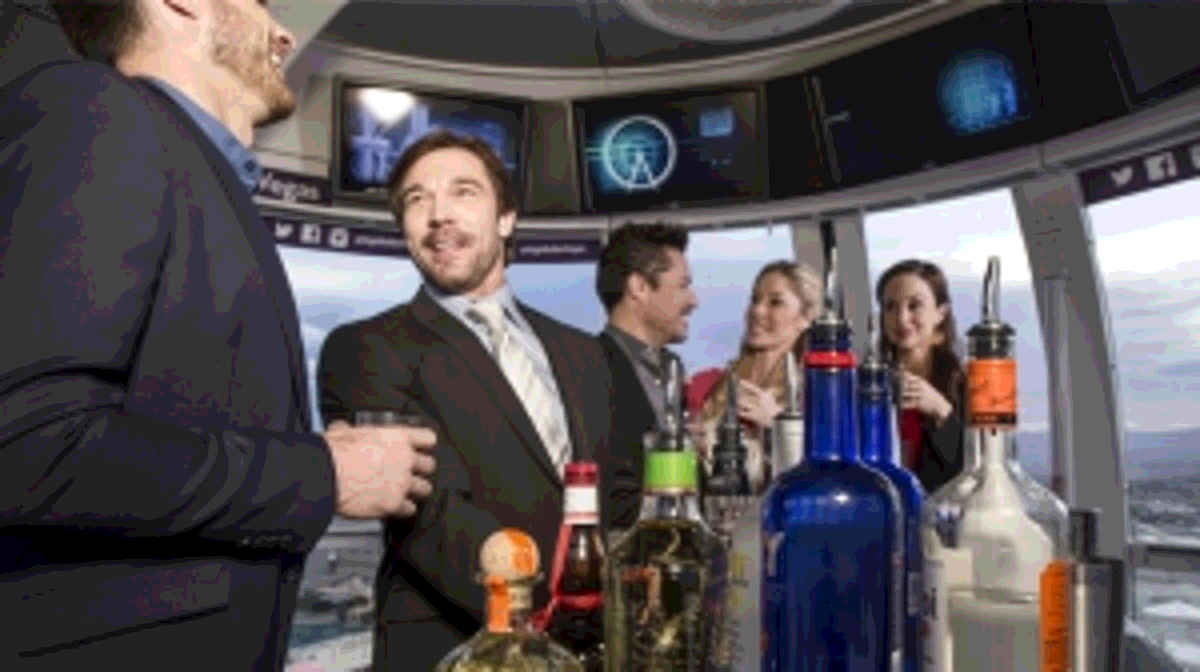 A group of professionals enjoy happy hour in an open bar cabin aboard the High Roller, the world's tallest observation wheel