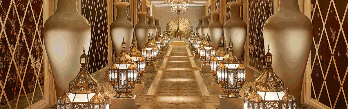 A corridor at The Spa at Encore, with golden lamps, vases, and a peacock statue
